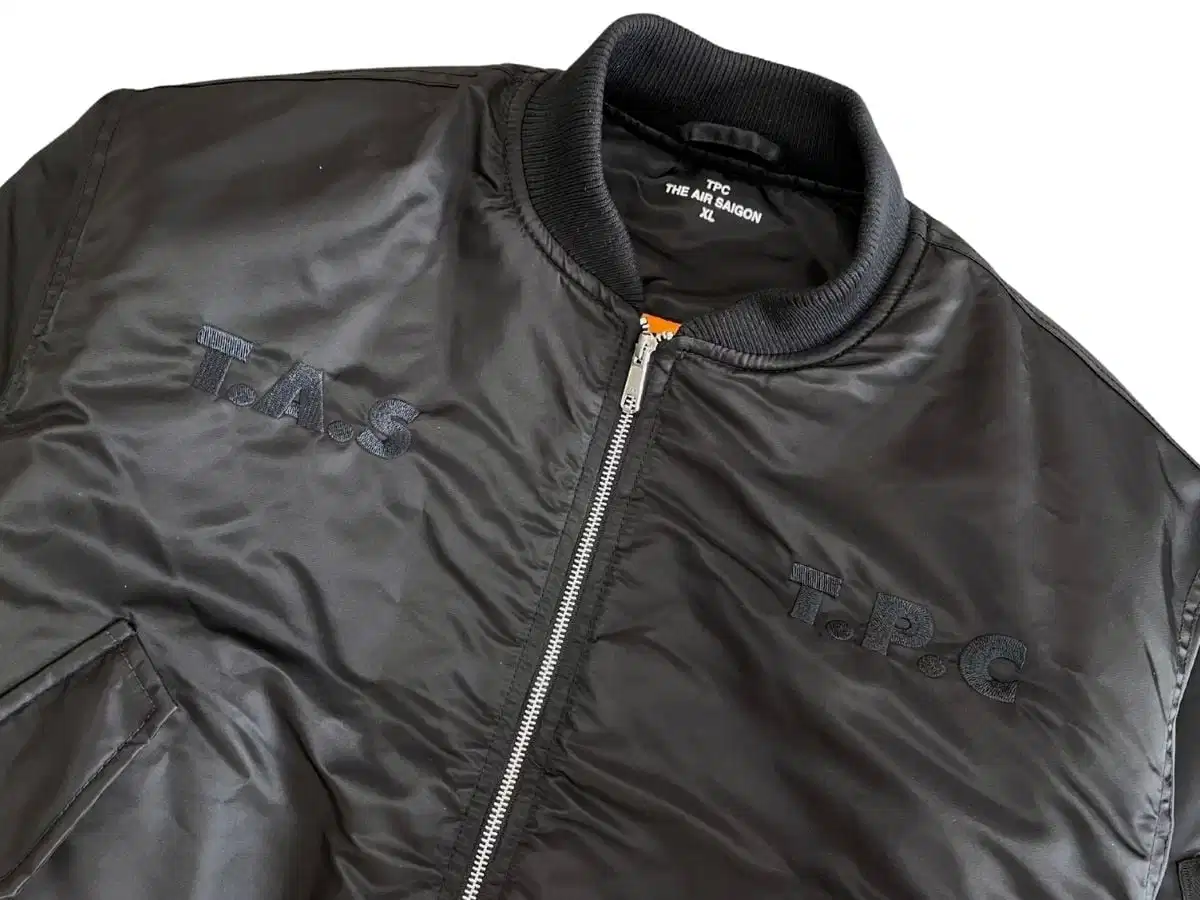 Cận cảnh tem mác và đường may của áo khoác bomber Cận cảnh tem mác và đường may của áo khoác bomber