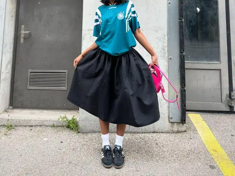 Chân váy midi phối cùng giày sneaker đen nữ