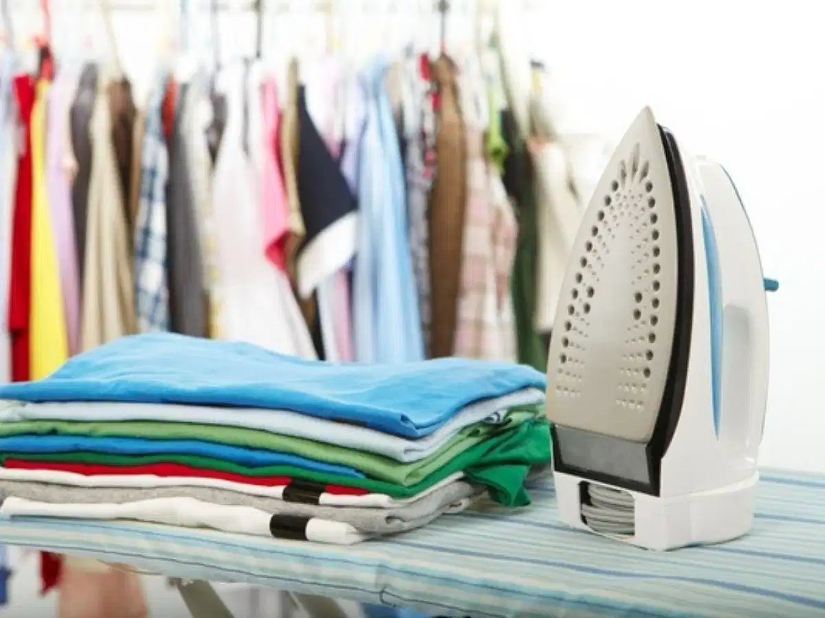 Là phẳng phần lá cổ và nẹp cúc bằng bàn ủi hơi nước Ủi hoặc là hơi áo polo trước khi tiến hành gấp cất tủ